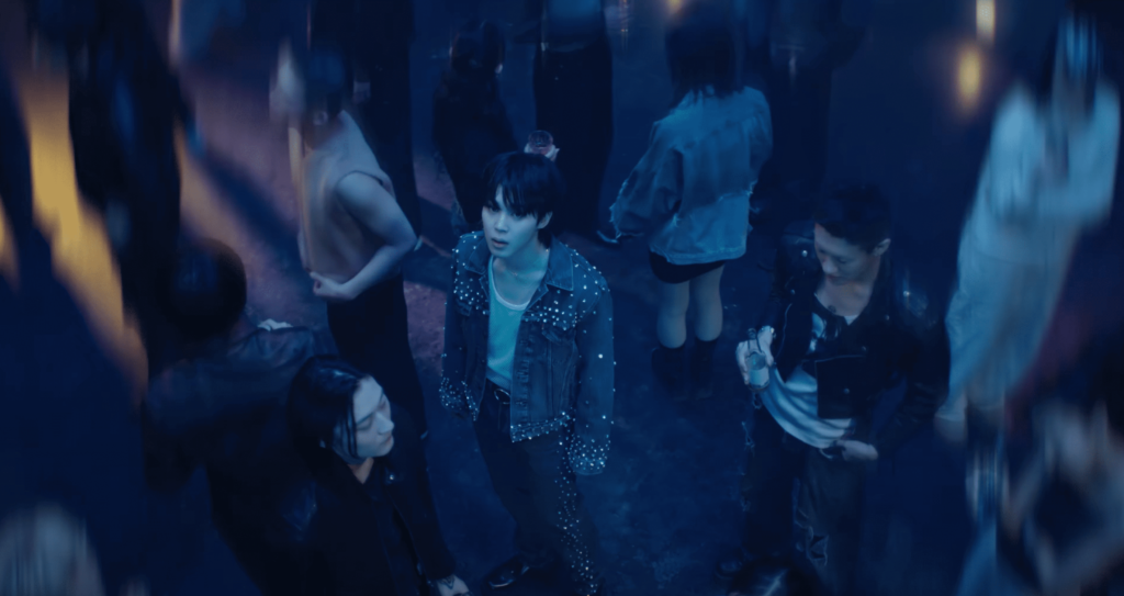 Jimin en el videoclip de Like Crazy rodeado de gente en la discoteca